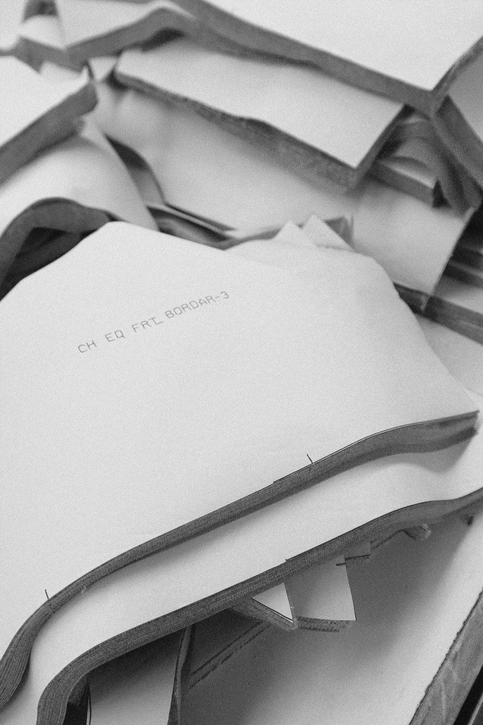 Paper patterns placed over stacks of cut garment components.