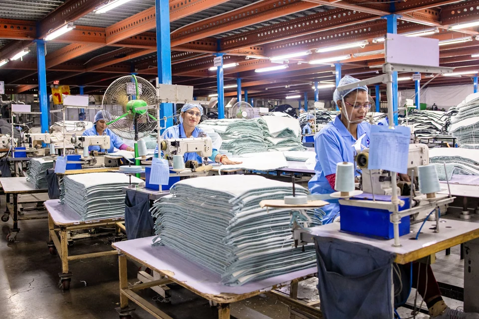 A wide view of people working at stations in a textile workshop.